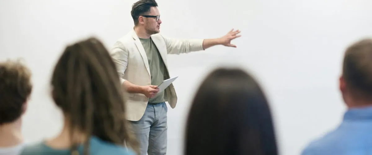 The image depicts a stock market training session led by a knowledgeable instructor for aspiring learners